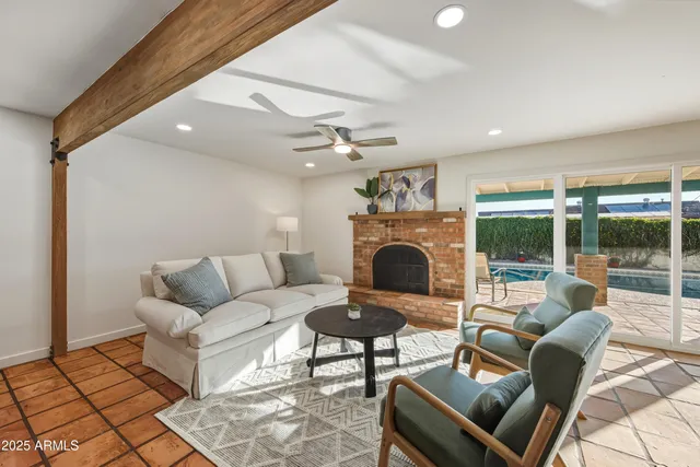 a living room with furniture a fireplace and a floor to ceiling window