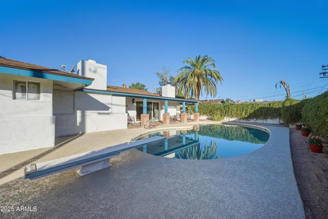 a bedroom with a bed and a lamp on dresser