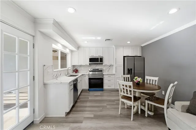 a kitchen with a white cabinets and chairs