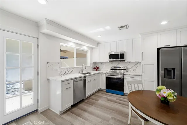 a kitchen with stainless steel appliances granite countertop a stove refrigerator and a sink