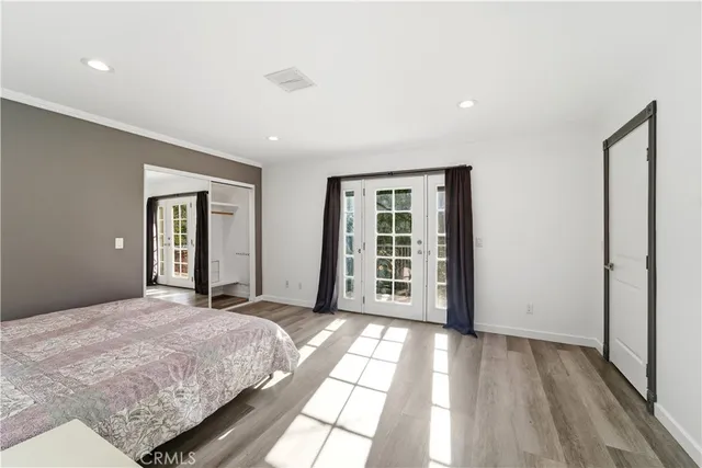 a view of a bedroom with wooden floor and windows