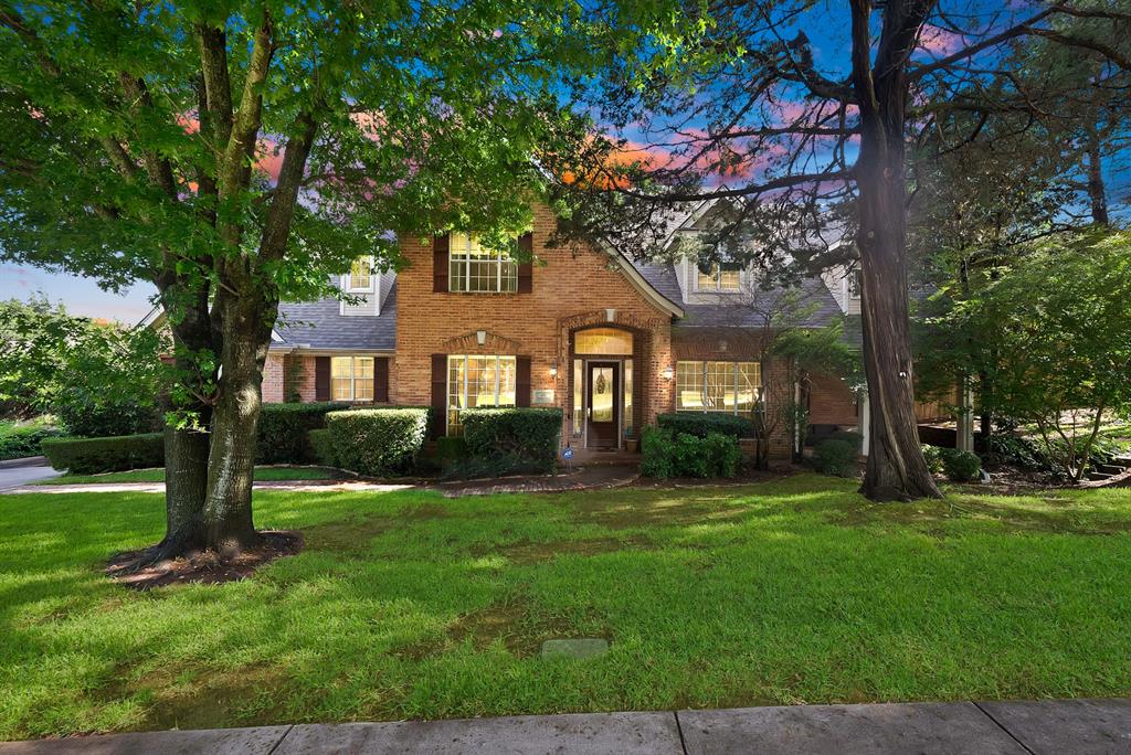 Brick facade residence with dormer windows, featuring a prominent front entry with a transom window
