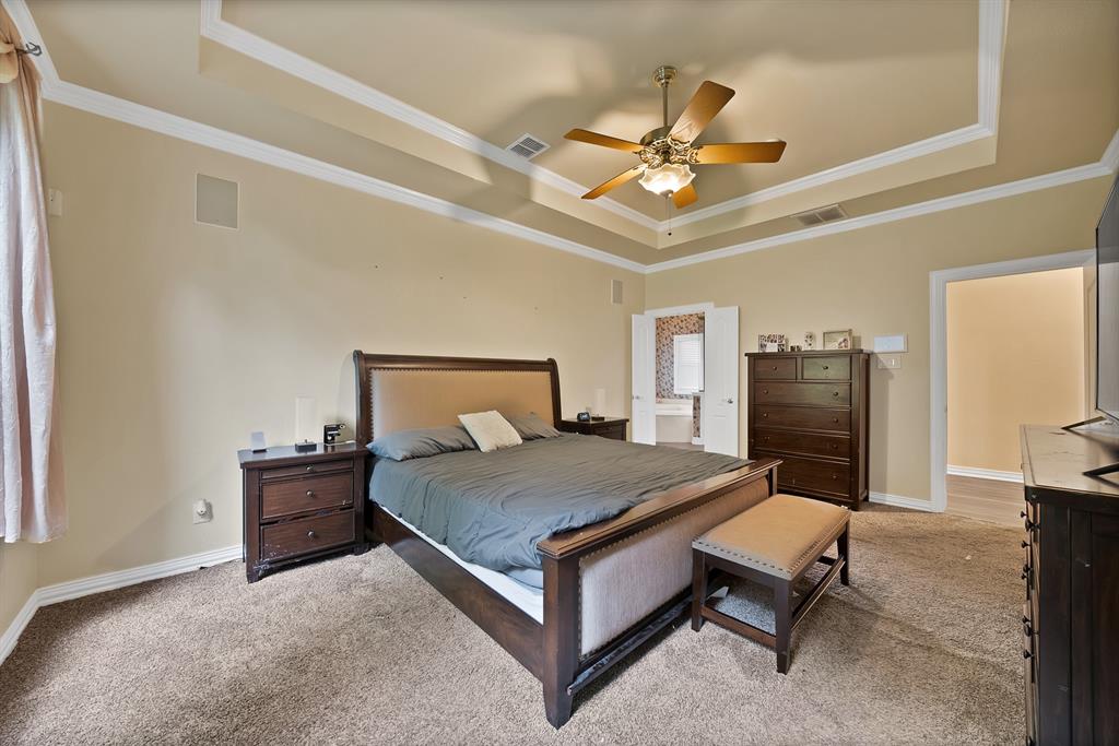 1912 Timber Ridge Court Cedar Hill, TX 75104 - Photo 15 of 35 Recessed tray ceiling with decorative molding, ceiling fan with integrated lighting, and neutral tone walls