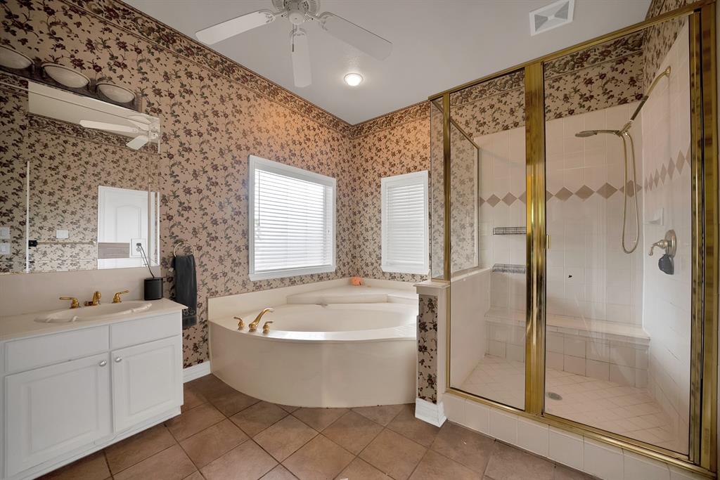 1912 Timber Ridge Court Cedar Hill, TX 75104 - Photo 16 of 35 Full bathroom featuring a corner soaking tub, a separate glass-enclosed shower with built-in seating, and a single vanity with a white countertop