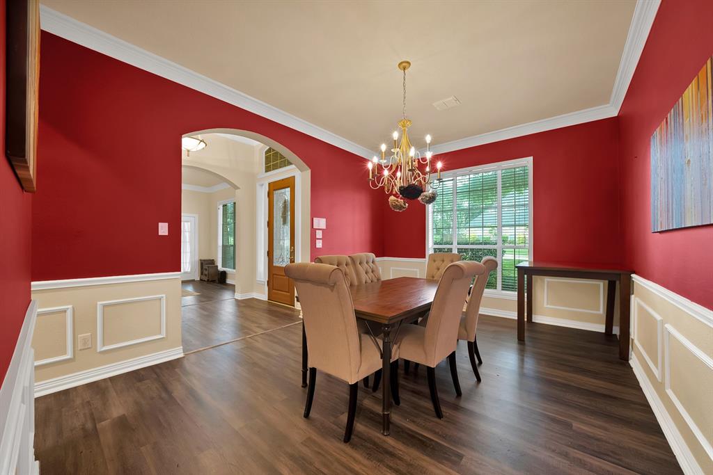 1912 Timber Ridge Court Cedar Hill, TX 75104 - Photo 20 of 35 Dining room featuring wood-finish flooring, wainscoting, crown molding, and a chandelier