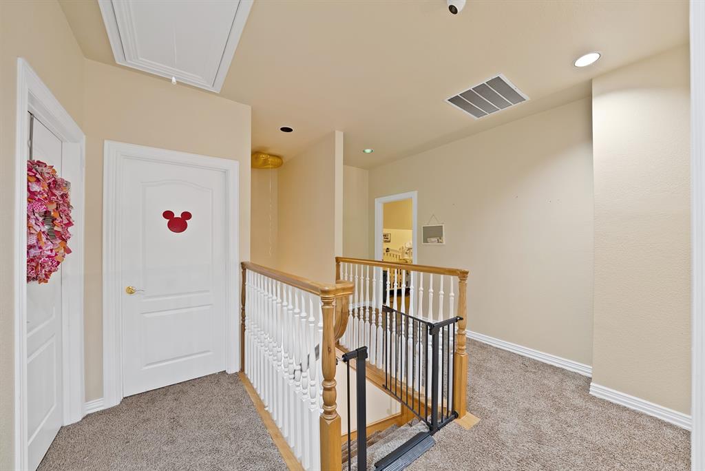 1912 Timber Ridge Court Cedar Hill, TX 75104 - Photo 21 of 35 Upper-level hallway featuring a wooden handrail with white spindles, recessed lighting, and textured beige walls
