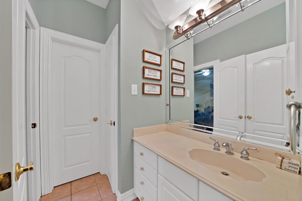 1912 Timber Ridge Court Cedar Hill, TX 75104 - Photo 26 of 35 Bathroom vanity featuring an integrated sink, polished chrome faucet, and white cabinetry with brass hardware
