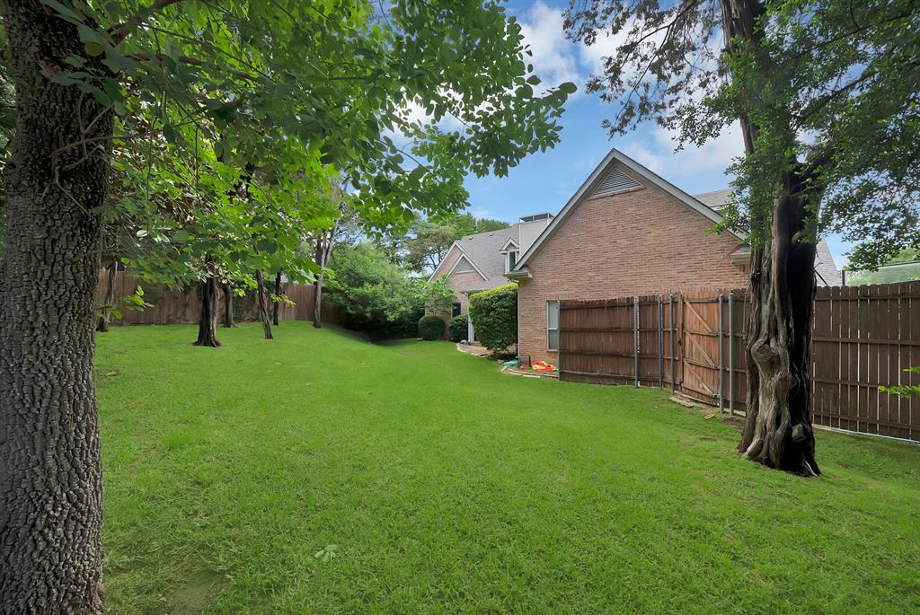 1912 Timber Ridge Court Cedar Hill, TX 75104 - Photo 30 of 35 Expansive grassy yard featuring mature trees and a wood privacy fence