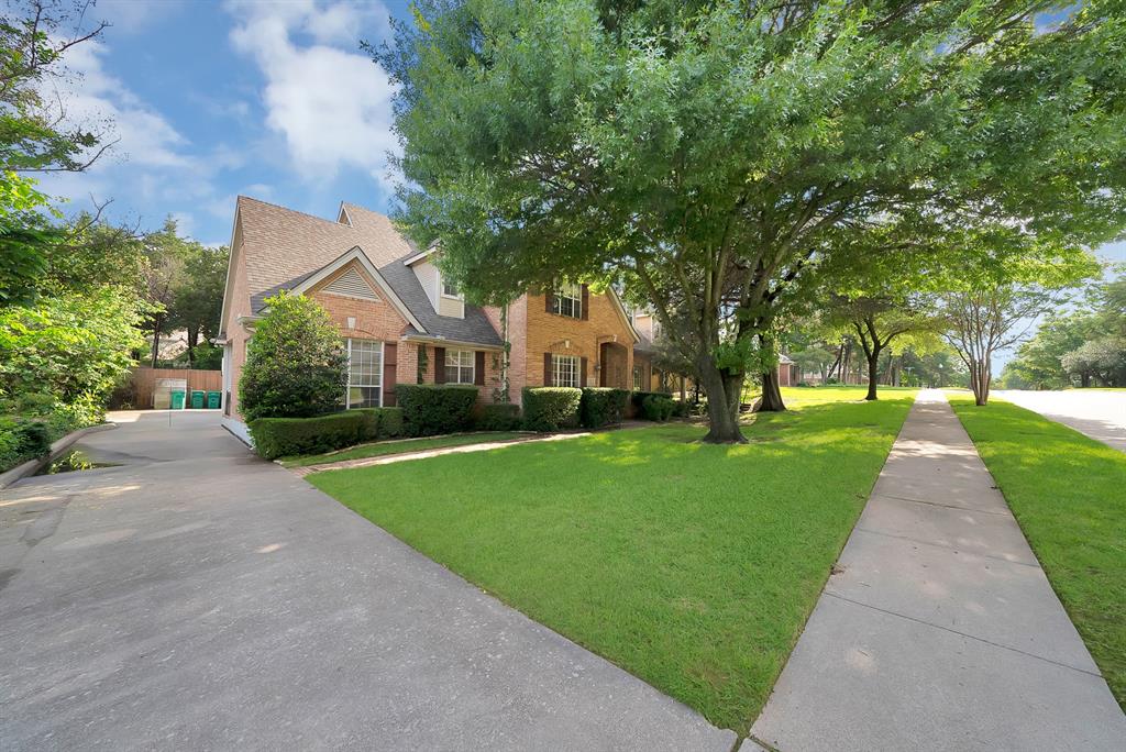 1912 Timber Ridge Court Cedar Hill, TX 75104 - Photo 3 of 35 Traditional brick exterior with an attached garage, a mature tree providing shade, a well-maintained lawn, a concrete driveway, and a sidewalk