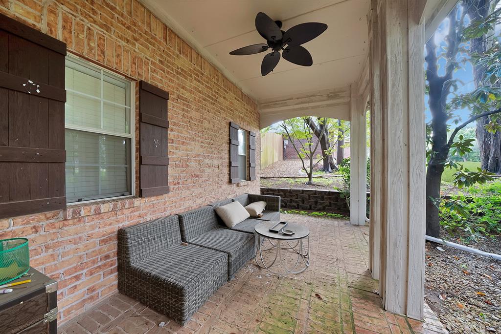 1912 Timber Ridge Court Cedar Hill, TX 75104 - Photo 31 of 35 Covered brick patio featuring a ceiling fan, brick flooring, white support pillars, and exterior windows with shutters