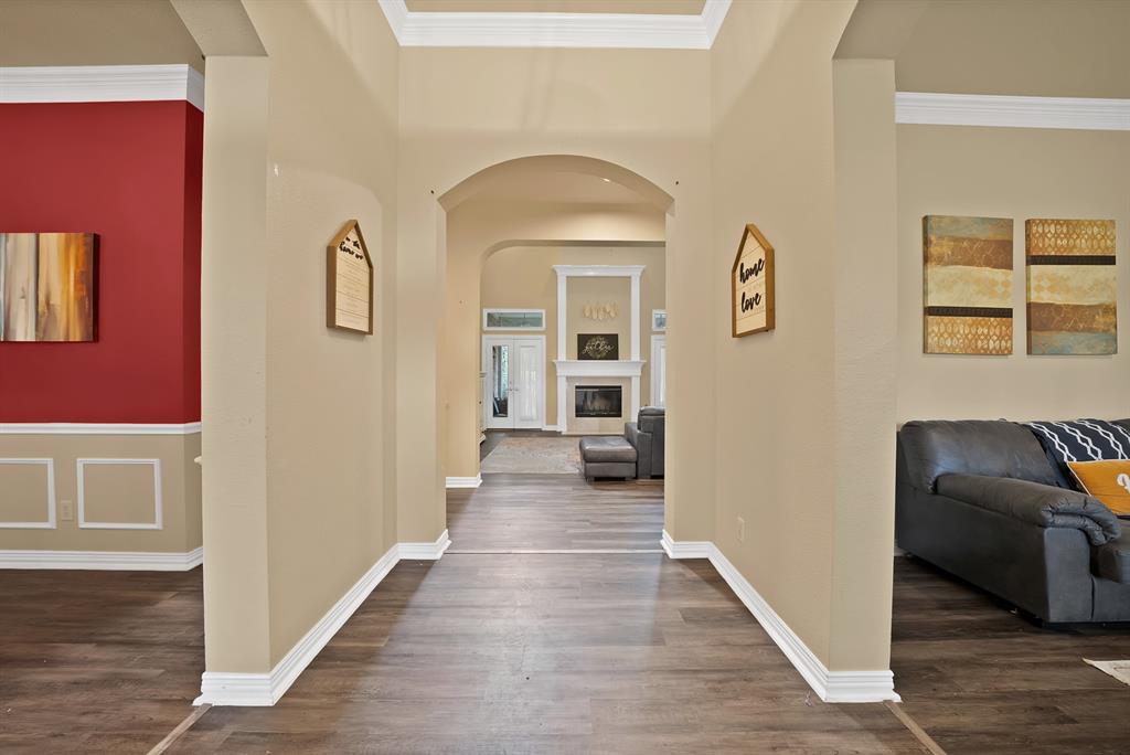 1912 Timber Ridge Court Cedar Hill, TX 75104 - Photo 6 of 35 Long entryway featuring wood-finish flooring, an arched doorway, crown molding, and baseboards