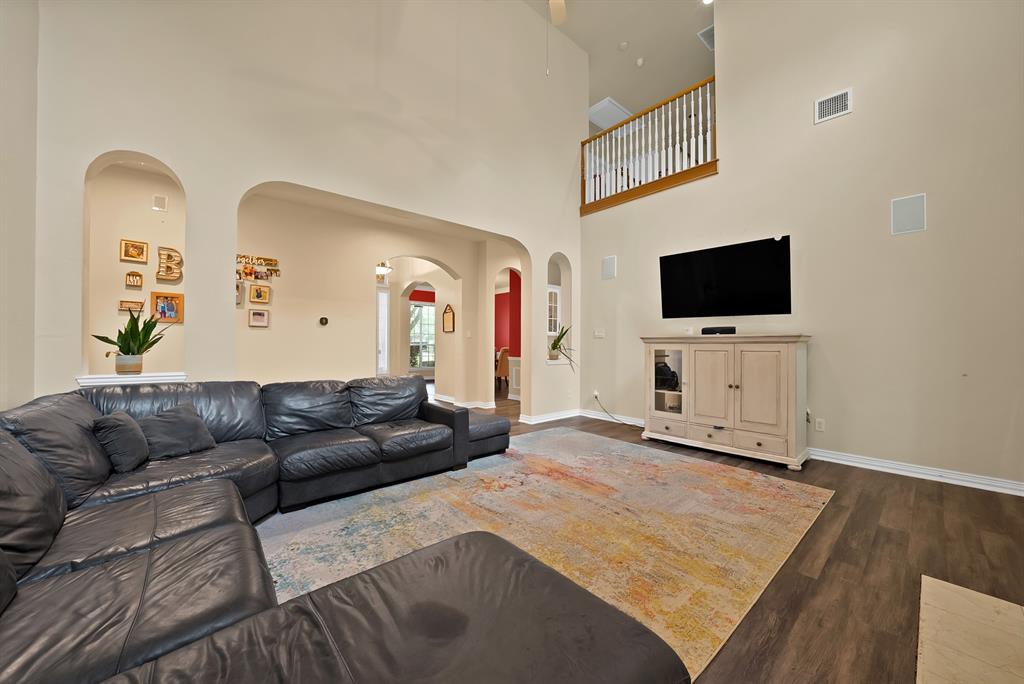 1912 Timber Ridge Court Cedar Hill, TX 75104 - Photo 9 of 35 Living area featuring wood-finish flooring, high ceilings, arched wall niches, and an upper-level railing
