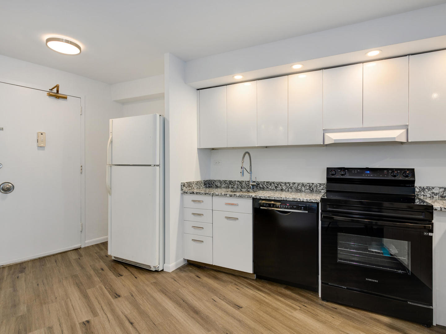 300 North State Street, Unit 3330 Chicago, IL 60654 - Photo 6 of 20 a kitchen with a refrigerator stove and white cabinets