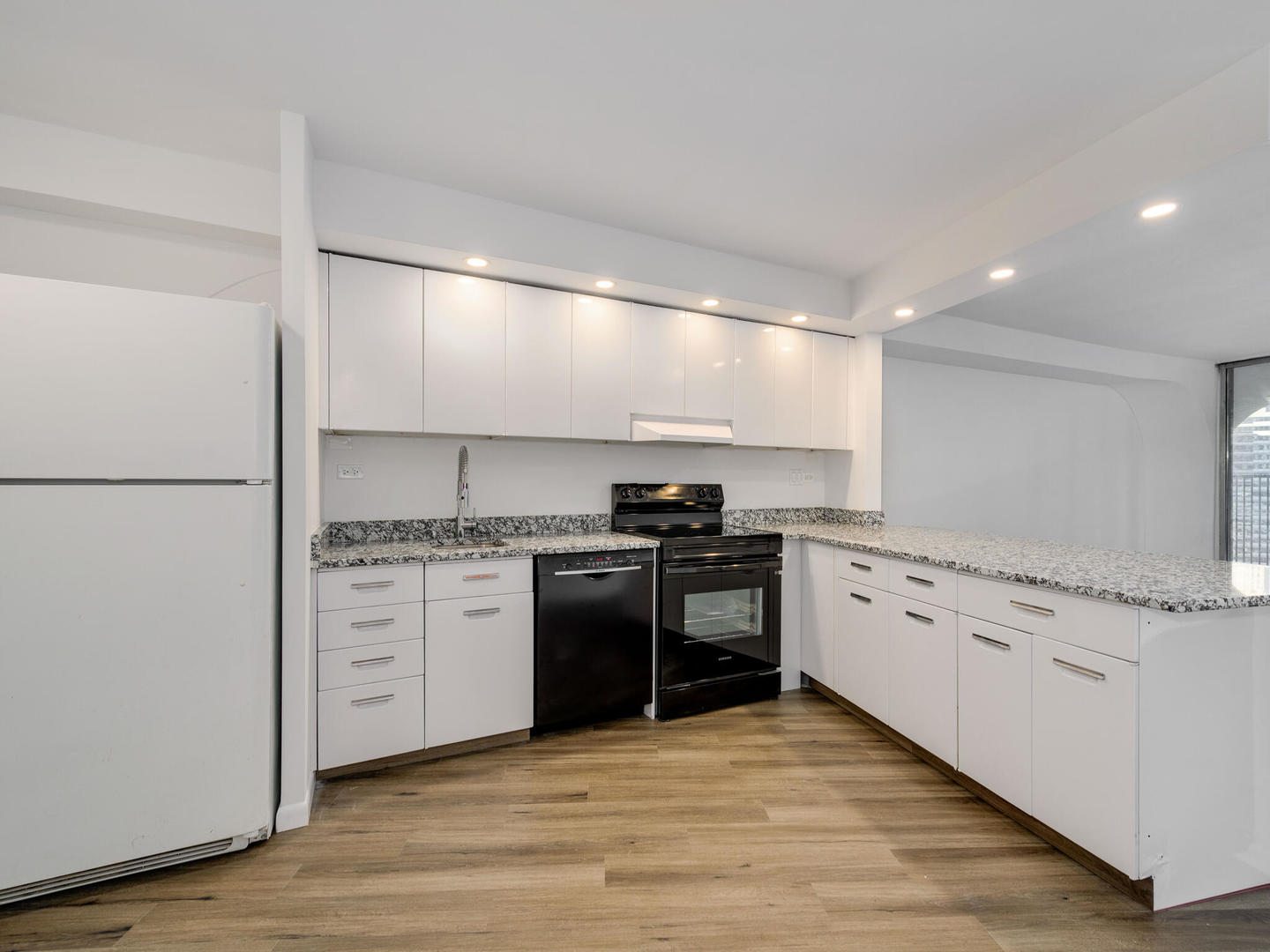300 North State Street, Unit 3330 Chicago, IL 60654 - Photo 7 of 20 a kitchen with granite countertop a sink cabinets stainless steel appliances and wooden floor