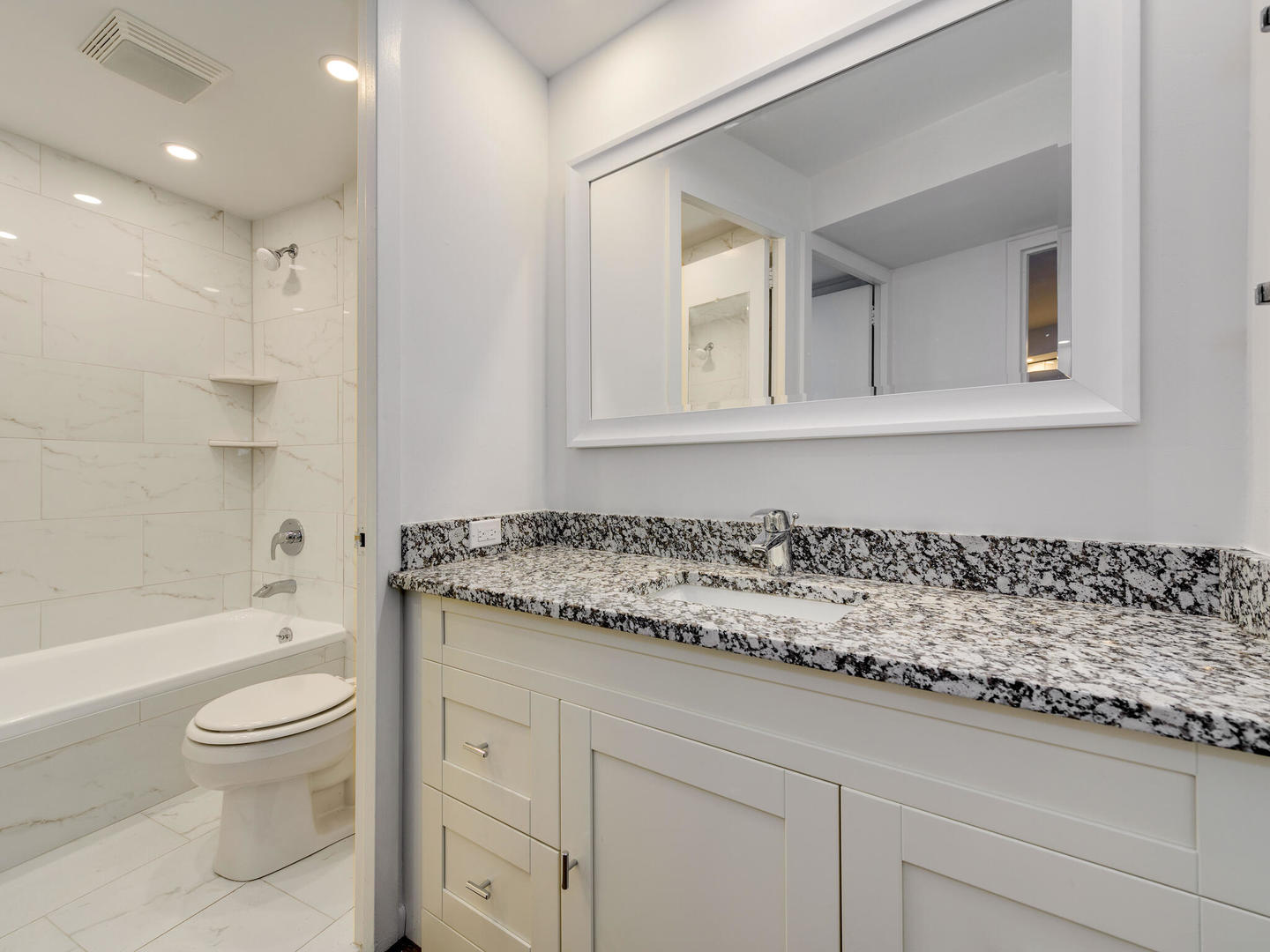 300 North State Street, Unit 3330 Chicago, IL 60654 - Photo 10 of 20 a bathroom with a granite countertop toilet a sink a mirror and bathtub