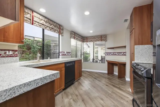 a kitchen with stainless steel appliances granite countertop a stove a sink and a wooden floors