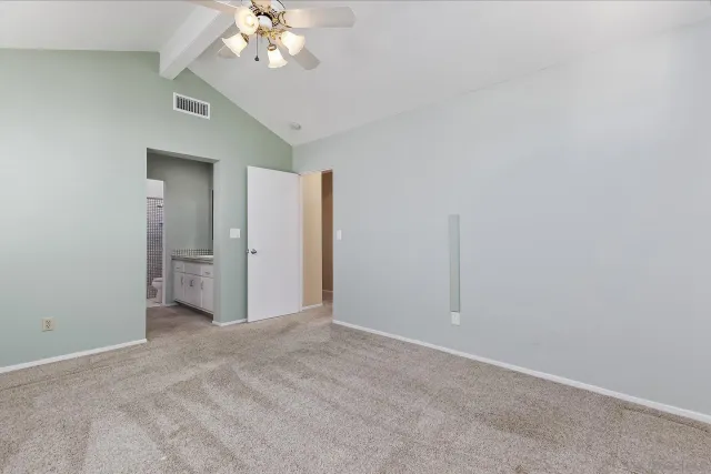 a view of an empty room with a chandelier fan