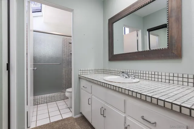 a bathroom with a granite countertop sink and a mirror