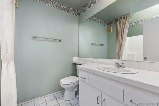 a bathroom with a sink toilet and a mirror