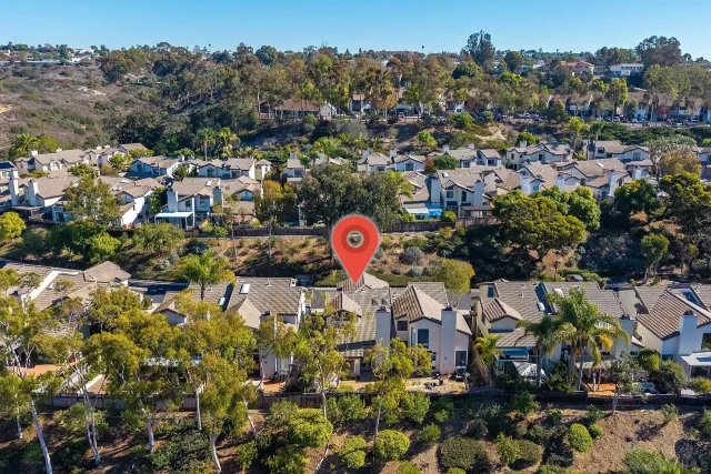 a view of a backyard with chairs under an umbrella