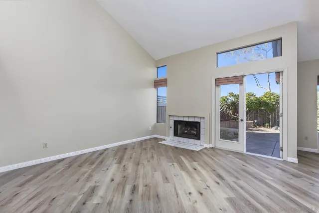 a view of empty room with wooden floor and fireplace