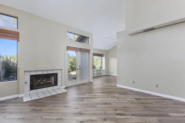 a view of an empty room with window and fire place