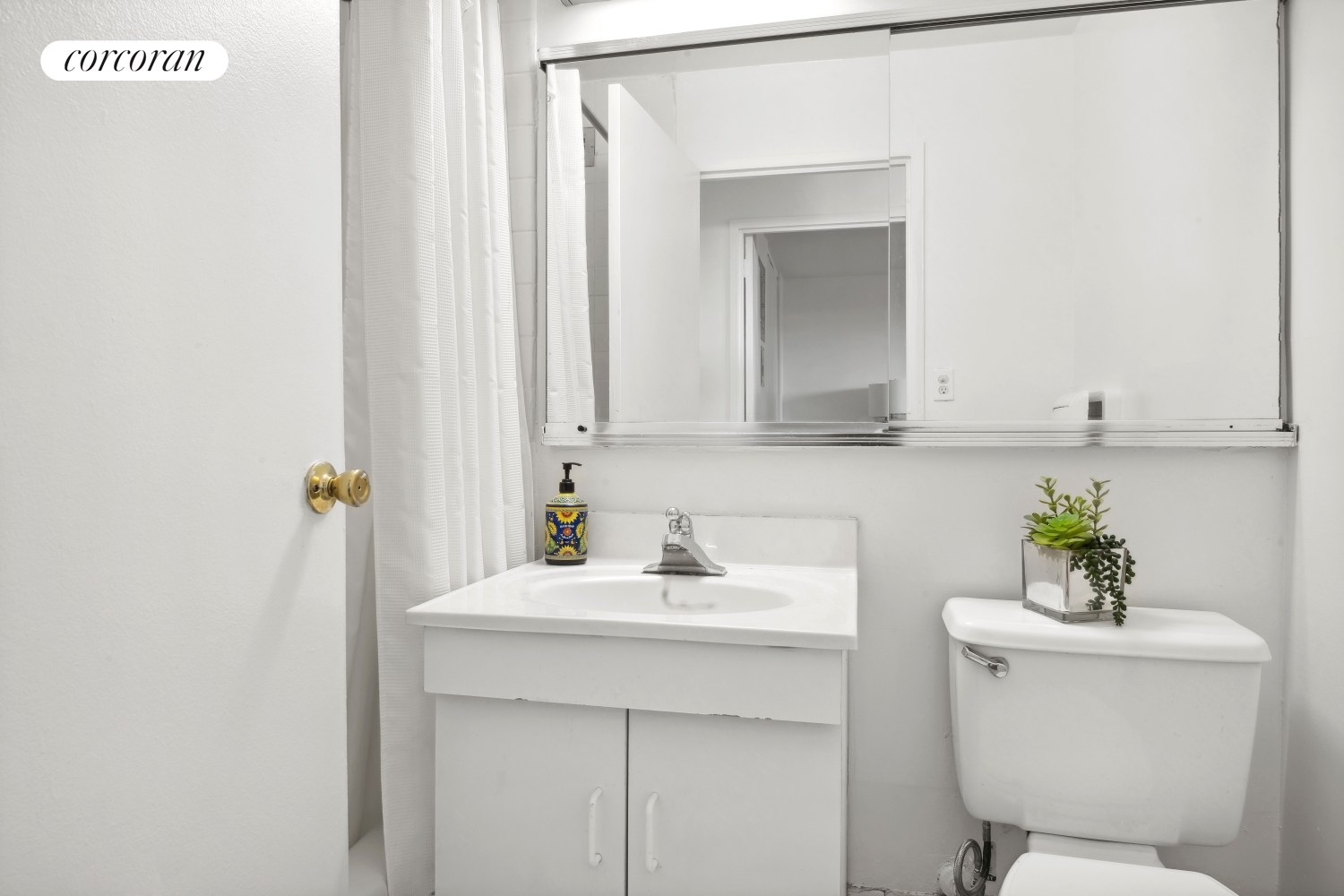 575 Main Street, Unit 1408 Manhattan, NY 10044 - Photo 5 of 17 a bathroom with a sink toilet and vanity