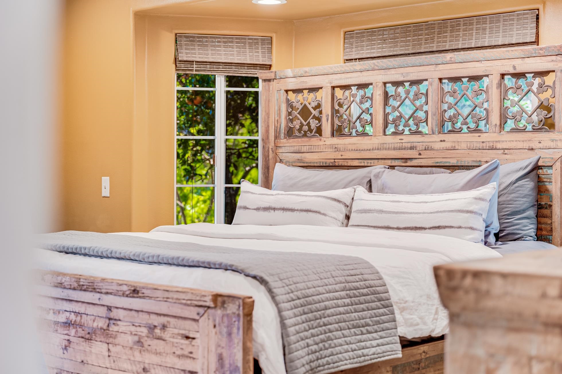 951 Kokomo Road Haiku, HI 96708 - Photo 15 of 50 a bedroom with a bed and a large window