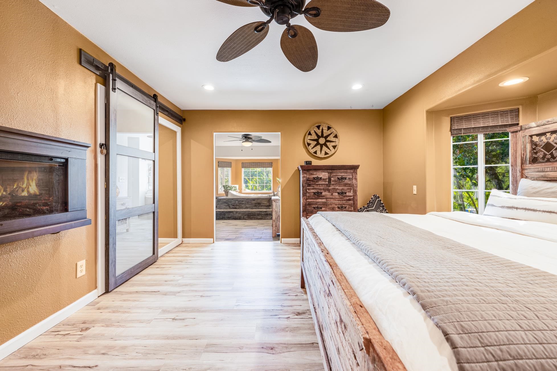 951 Kokomo Road Haiku, HI 96708 - Photo 17 of 50 a spacious bedroom with a bed and dresser with wooden floor
