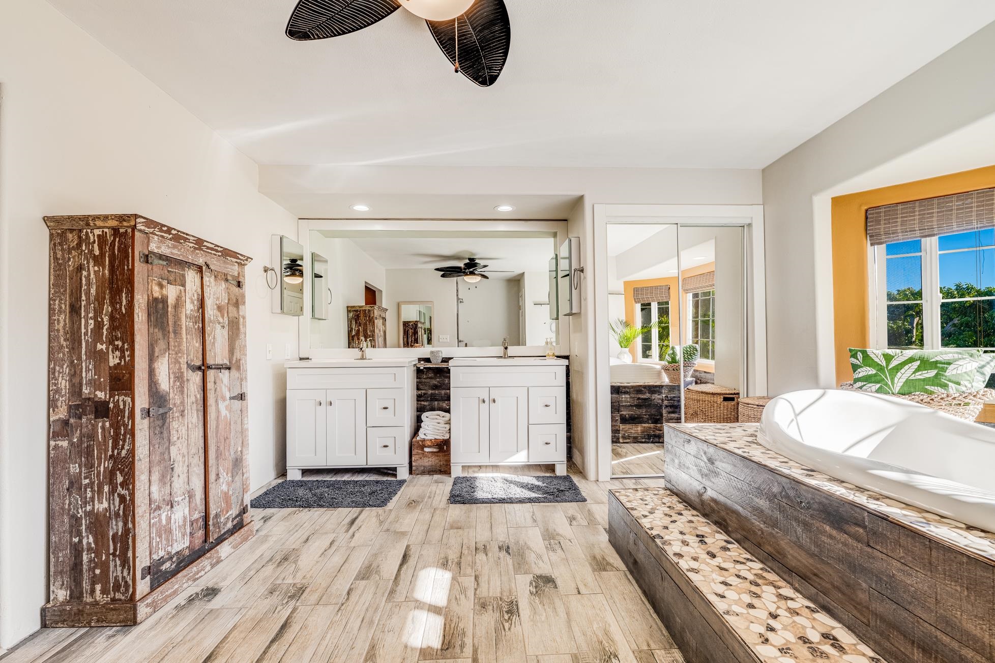 951 Kokomo Road Haiku, HI 96708 - Photo 22 of 50 a large bedroom with a bed and wooden floor