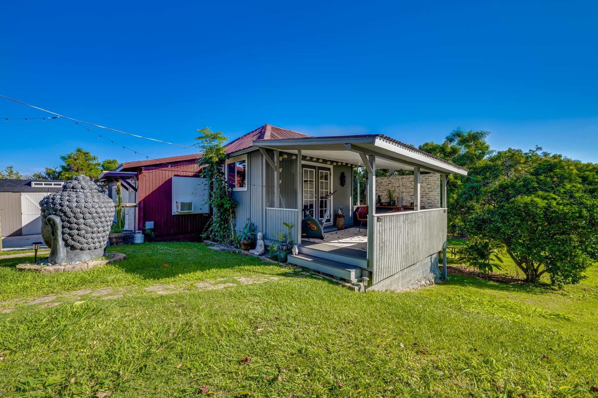 951 Kokomo Road Haiku, HI 96708 - Photo 33 of 50 a view of a house with backyard porch and garden