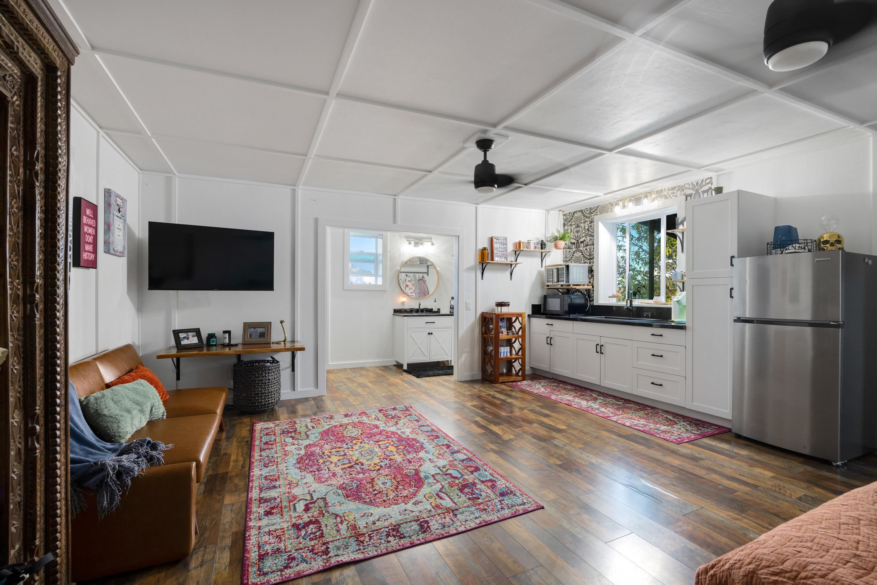 951 Kokomo Road Haiku, HI 96708 - Photo 45 of 50 a kitchen with stainless steel appliances kitchen island granite countertop a stove refrigerator and microwave
