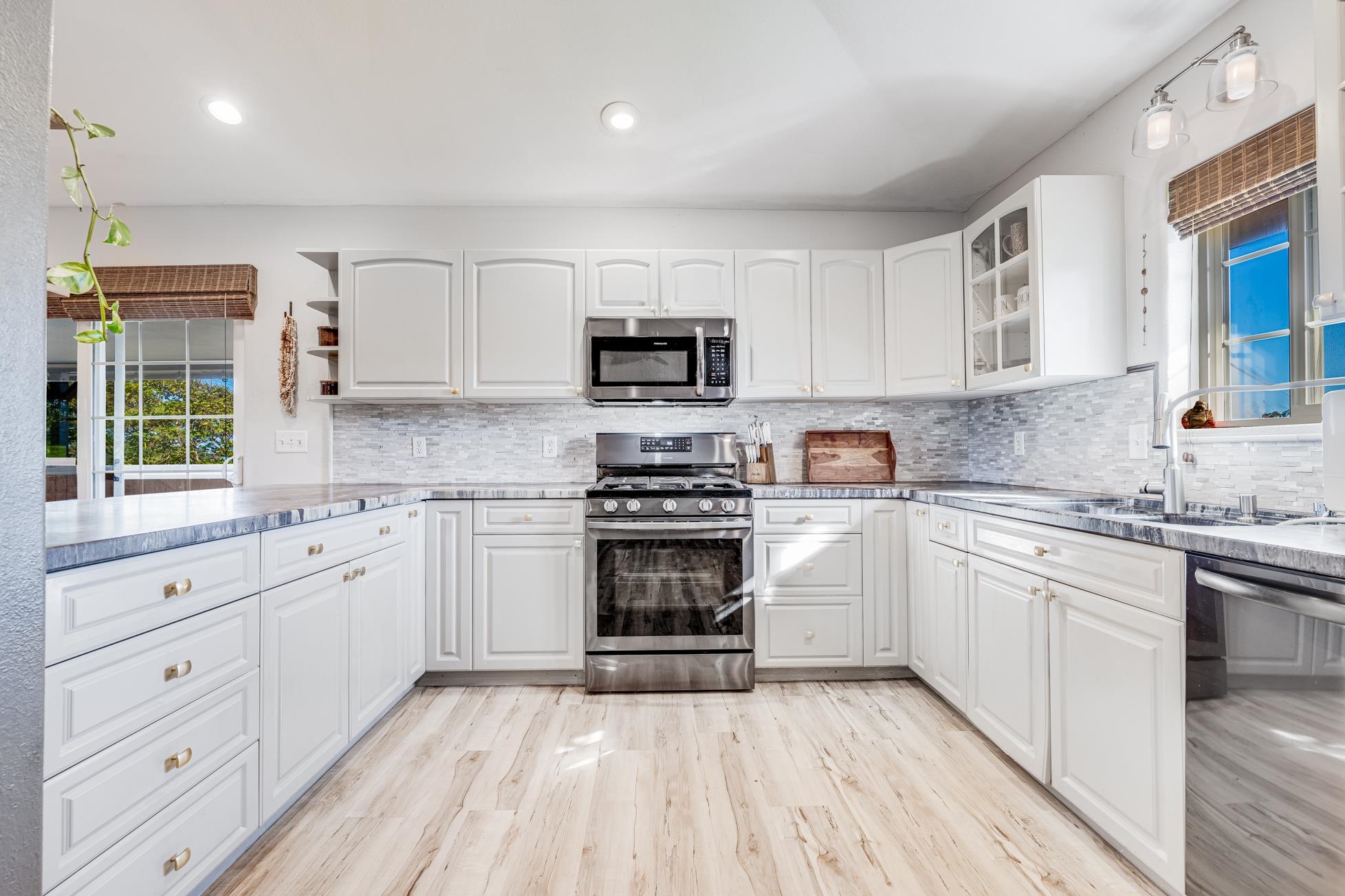 951 Kokomo Road Haiku, HI 96708 - Photo 6 of 50 a kitchen with granite countertop a stove top oven sink and cabinets