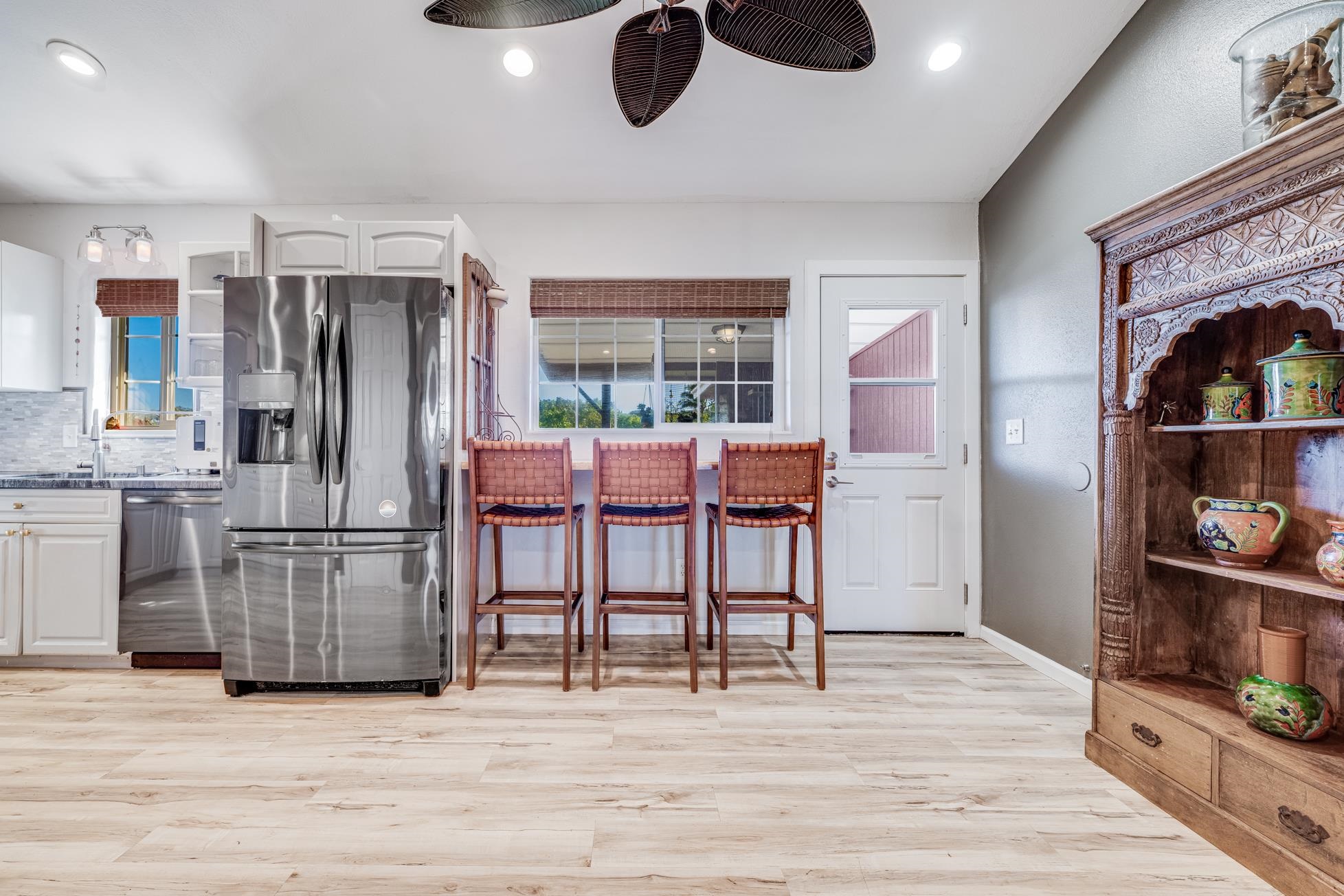 951 Kokomo Road Haiku, HI 96708 - Photo 7 of 50 a kitchen with stainless steel appliances granite countertop a refrigerator microwave and wooden floor