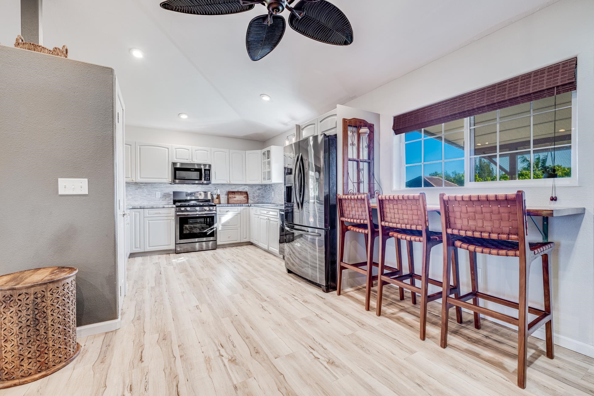 951 Kokomo Road Haiku, HI 96708 - Photo 8 of 50 a kitchen with stainless steel appliances kitchen island granite countertop a dining table chairs and granite counter tops