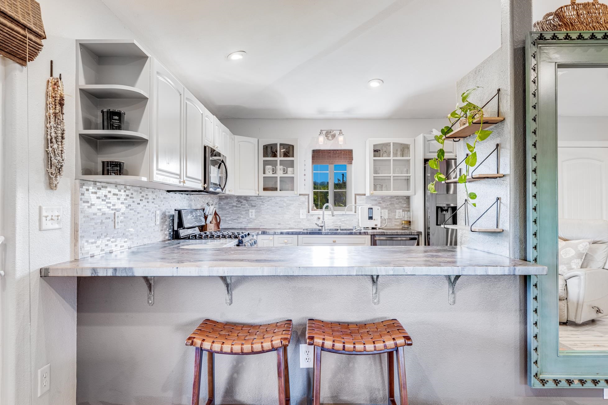 951 Kokomo Road Haiku, HI 96708 - Photo 9 of 50 a kitchen with stainless steel appliances granite countertop a sink and a stove