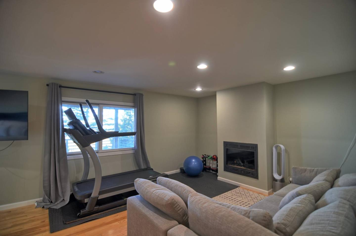 254 Swett Road Woodside, CA 94062 - Photo 11 of 26 a living room with furniture a fireplace and a floor to ceiling window