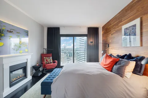 a bedroom with a bed a fireplace and a large window