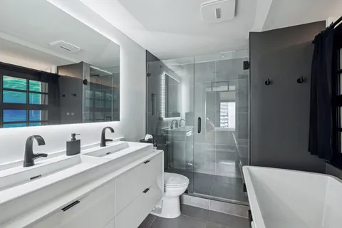 a bathroom with a double vanity sink toilet and shower