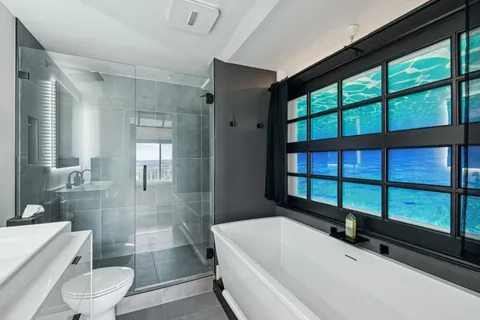 a bathroom with a sink a toilet and a large mirror