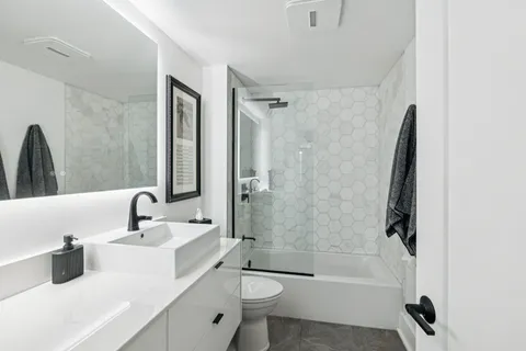 a bathroom with a sink a toilet and shower