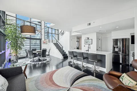 a living room with furniture kitchen view and a large window