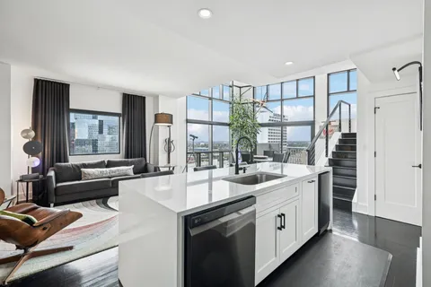 a large white kitchen with a sink and cabinets