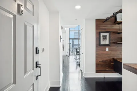 a view of a hallway with wooden floor and entryway
