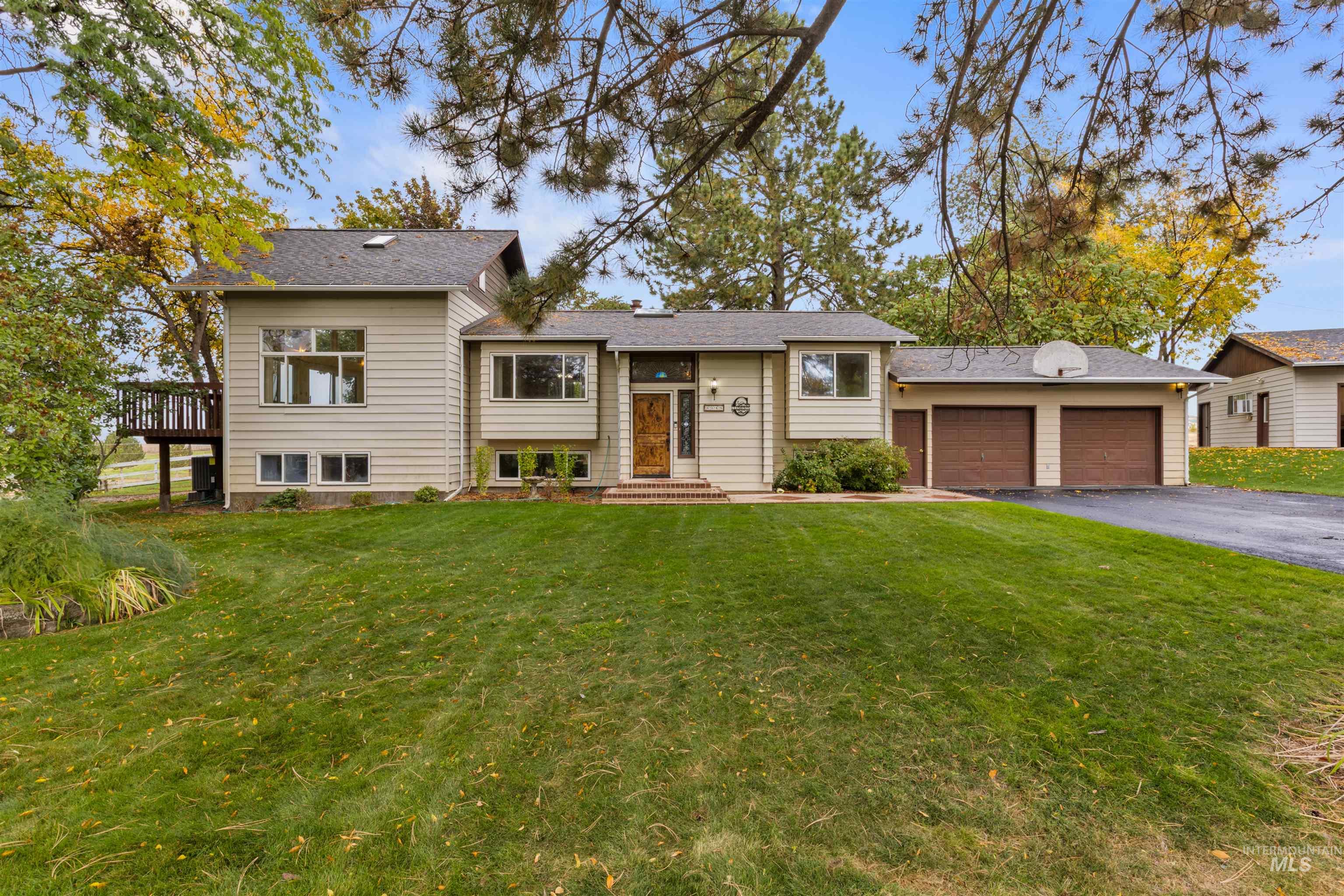 Bi-level home with a front yard, an attached garage, and driveway
