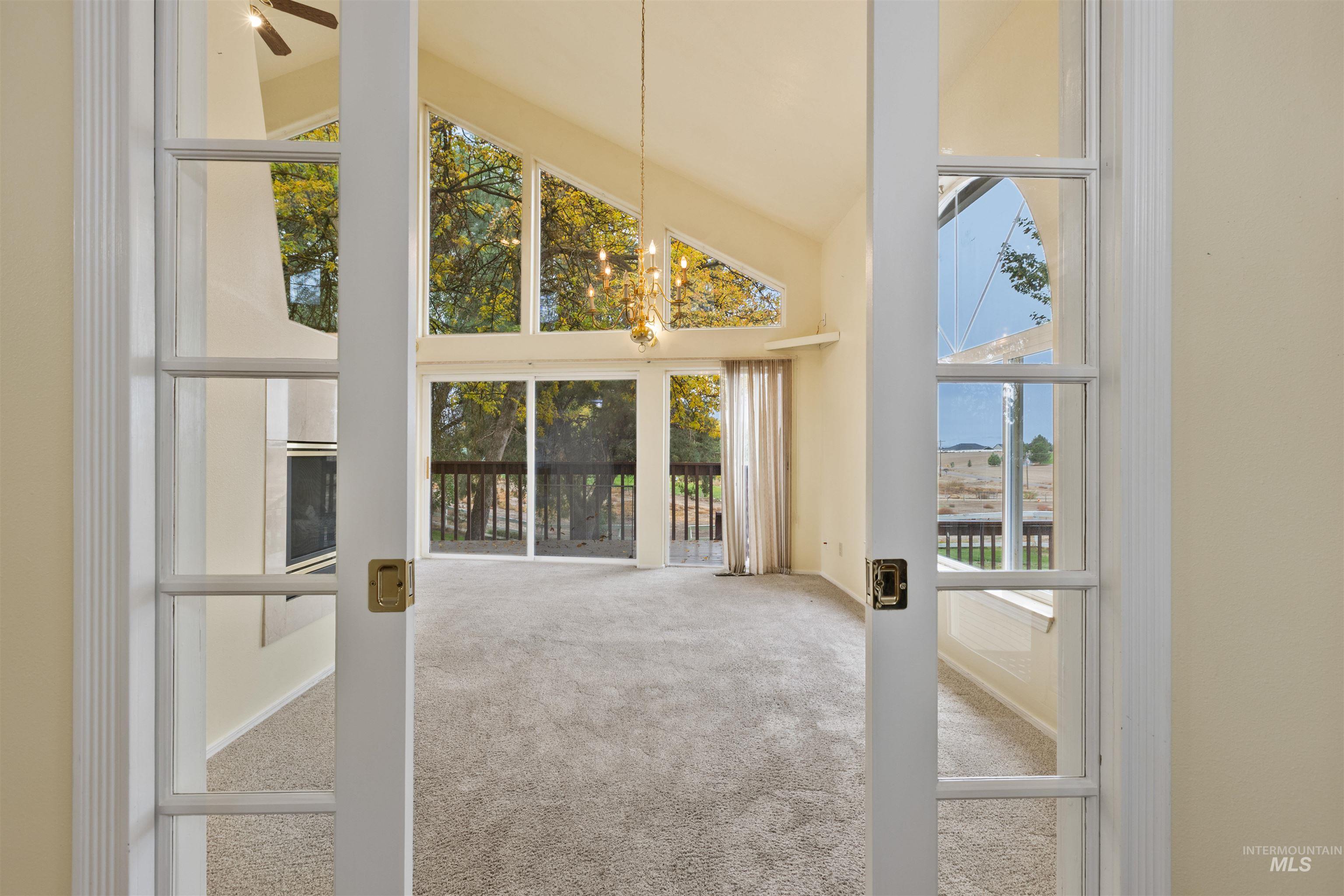 9948 Ash Lane Payette, ID 83661 - Photo 12 of 34 Unfurnished living room with carpet flooring, high vaulted ceiling, and ceiling fan