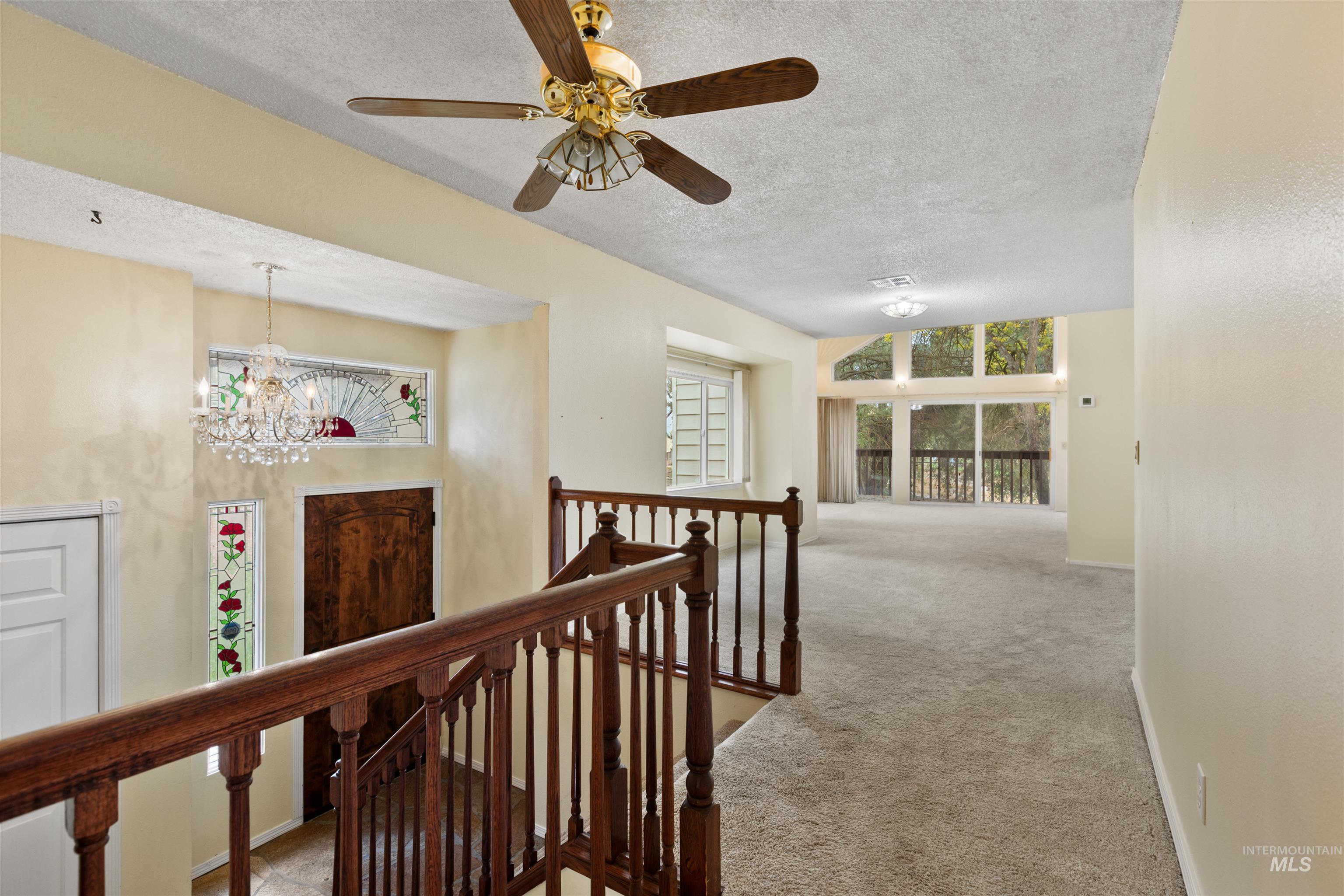 9948 Ash Lane Payette, ID 83661 - Photo 19 of 34 Hall with carpet, an upstairs landing, a textured ceiling, and a chandelier