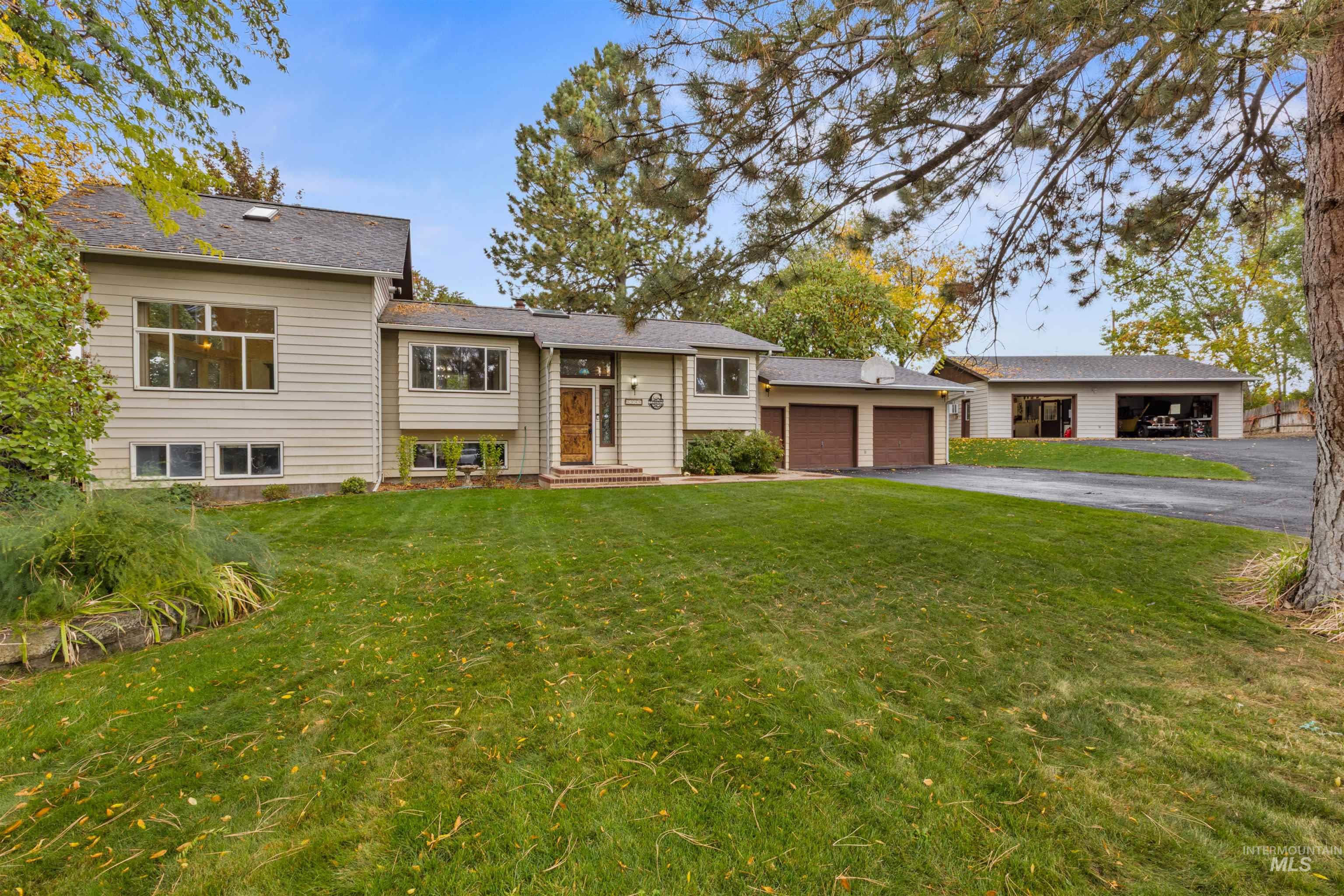9948 Ash Lane Payette, ID 83661 - Photo 2 of 34 Raised ranch with a front yard, asphalt driveway, and a garage