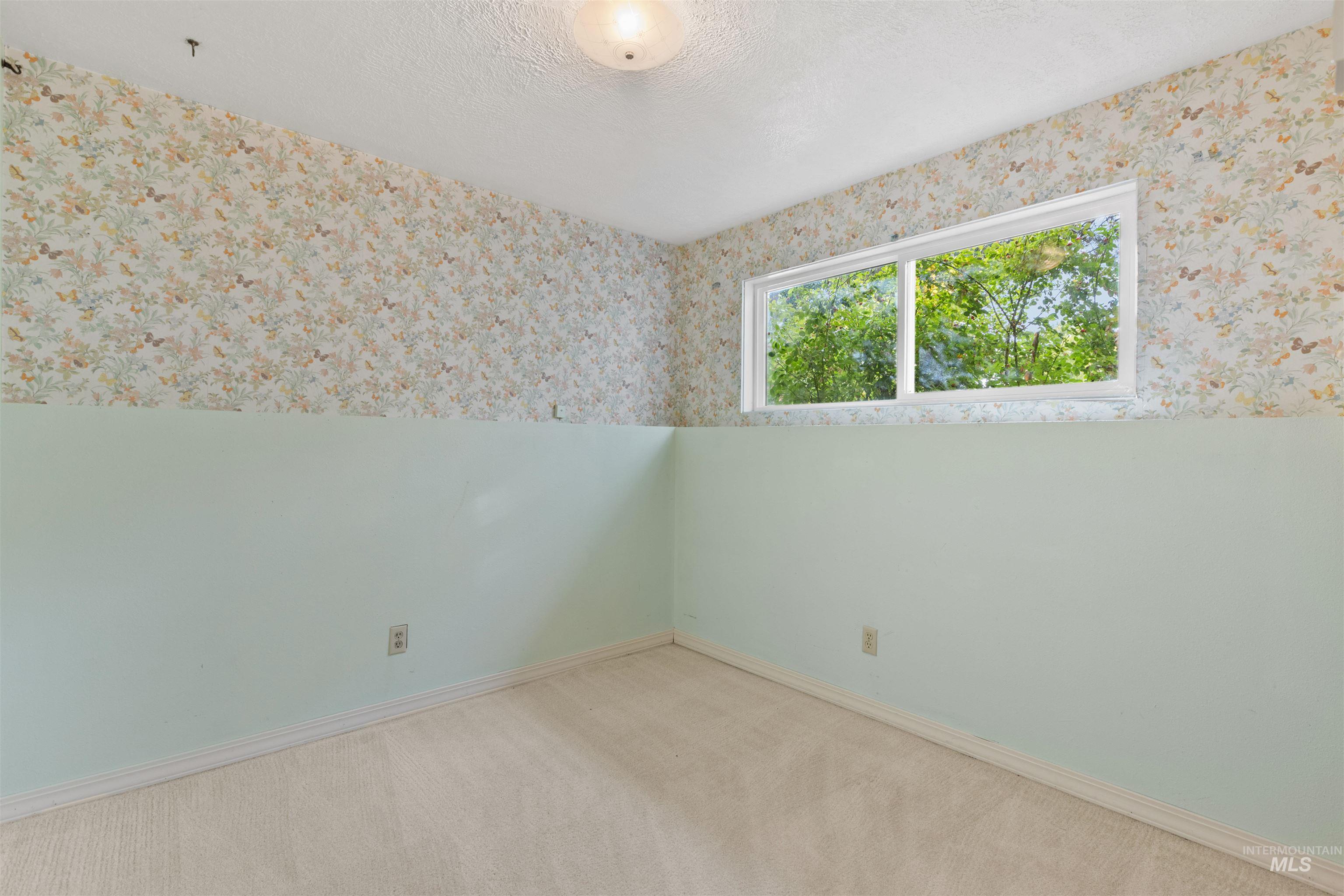 9948 Ash Lane Payette, ID 83661 - Photo 22 of 34 Carpeted spare room featuring a textured ceiling and wallpapered walls