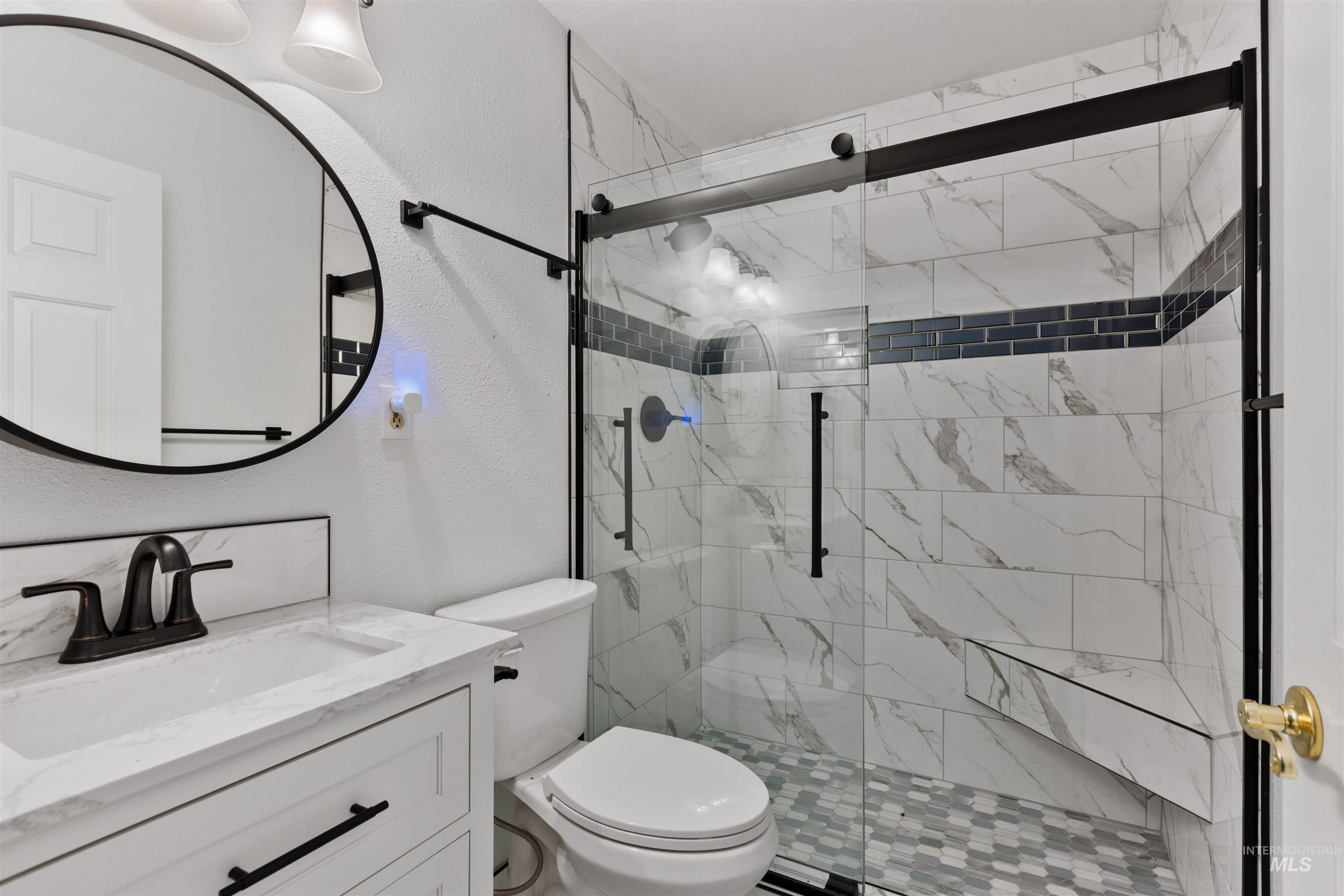 9948 Ash Lane Payette, ID 83661 - Photo 24 of 34 Bathroom featuring a textured wall, a shower stall, and vanity